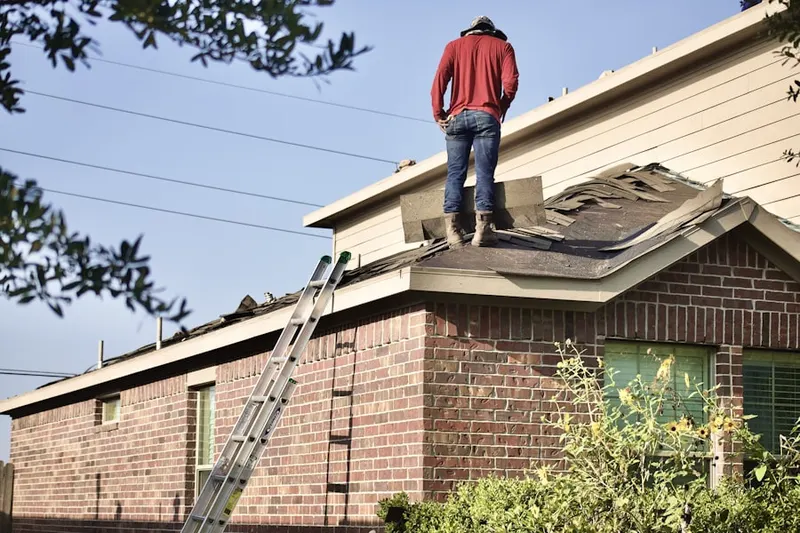 Professional roofer working on a residential roof in West End